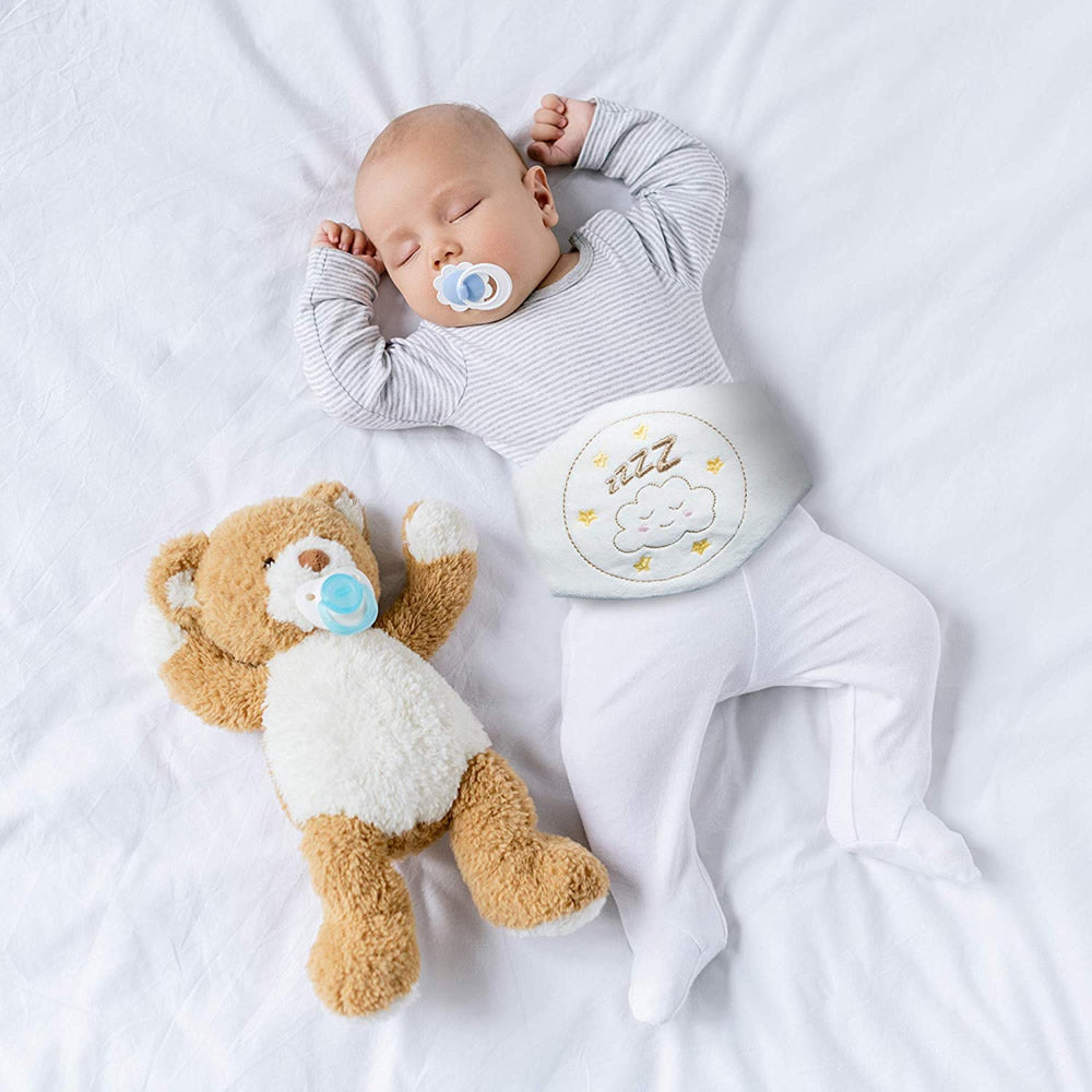 Baby mit Kirschkerngürtel beim Schlafen auf einer Decke