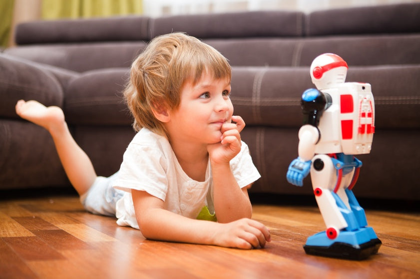 Kind auf dem Fußboden mit einen Spielzeug Roboter